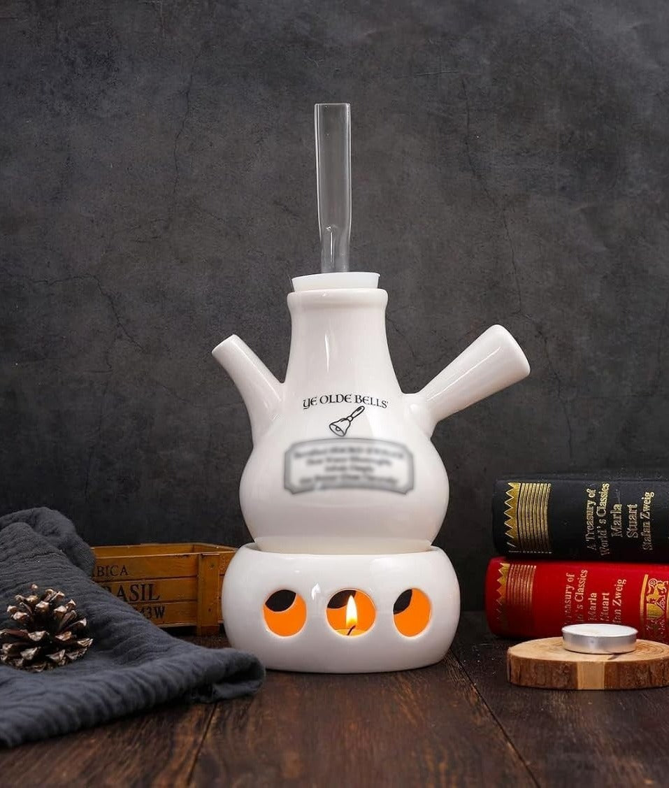Ye Olde Bells Victorian Vocal Steamer, a ceramic steam inhaler based on the classic Dr Nelson's inhaler design, on a wooden desk with a tealight glowing in the base